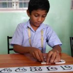 child molding letters in clay