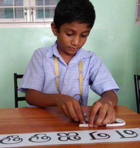 child molding letters in clay